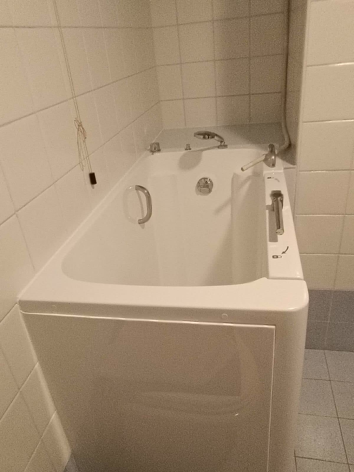 Vasca con sportello apribile montata in un bagno